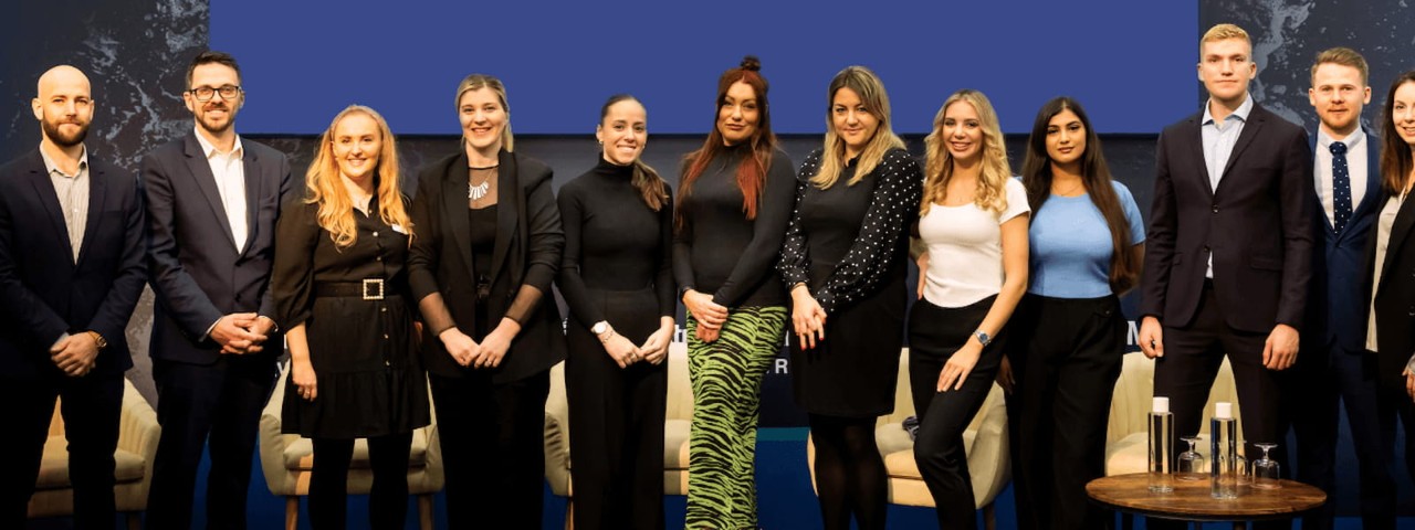 A group of people from different nationalities stands on a podium
